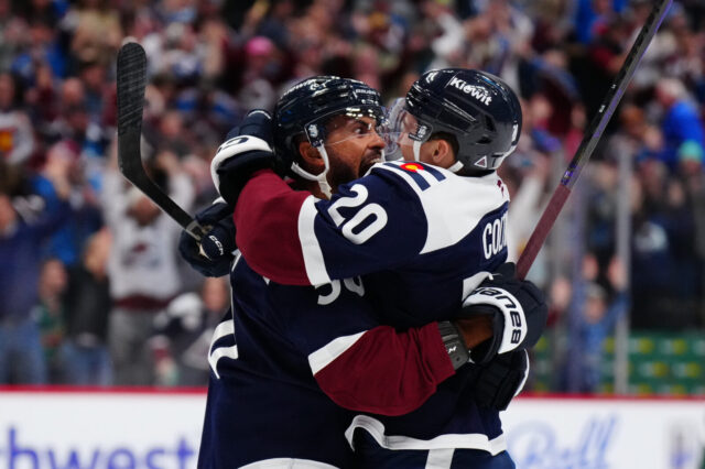 Oliver Kylington and Ross Colton celebrate after scoring a goal.