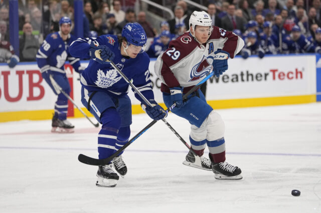 Nathan MacKinnon and Matthew Knies battle for the puck.